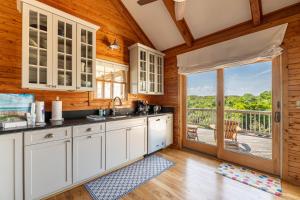 a kitchen with white cabinets and a view of a deck at Shore Enough - Duck, Sanderling, 50 Yds to Beach, Elevator, Pets OK, Community Pool, Flex Stays in Duck +48 photos