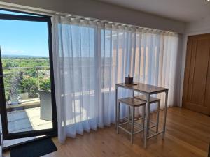 a room with a table and a large window at Room with a View in Glastonbury