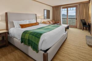 a hotel room with a large bed and a balcony at 3033 Suncadia Riverfront Studio Lodge Pool Access in Cle Elum +25 photos