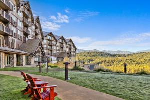 two benches sitting on a sidewalk in front of a building at 3033 Suncadia Riverfront Studio Lodge Pool Access in Cle Elum