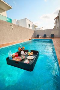 a tray of food sitting on top of a swimming pool at La Villa Tombouctou in Bingerville