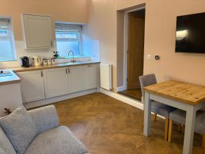 a kitchen with a table and a dining room at The Cow 'ouse, Wolds Way Holiday Cottages, 1 bed cottage in Little Weighton +10 photos