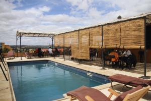 a swimming pool with chairs and a table and a building at Nosy Manga - Hotel Ivato Airport in Antananarivo