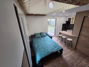 a bedroom with a bed and a kitchen with a table at la cabane de la régalante in Rannée