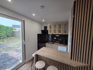 a kitchen with a counter and a large window at la cabane de la régalante in Rannée