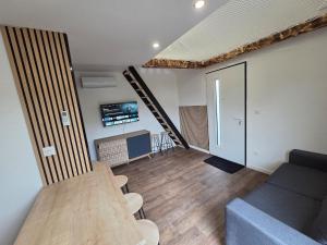 a living room with a table and a staircase at la cabane de la régalante in Rannée +8 photos