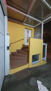a room with stairs and a yellow wall at Happy Corner in Varaždin +1 photo