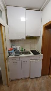 a small kitchen with a sink and white cabinets at Happy Corner in Varaždin