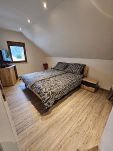 a bedroom with a bed and a wooden floor at 84m2 Ferienwohnung - Landquartier Moik Ankommen - Durchatmen - Abschalten in Ebenthal