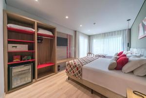 a bedroom with a large bed and a tv at Laghetto Stilo Borges - Apto 403B in Gramado