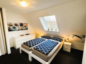 a bedroom with a bed with a blue comforter and a window at Business-Apartment Ahrensburg in Ahrensburg