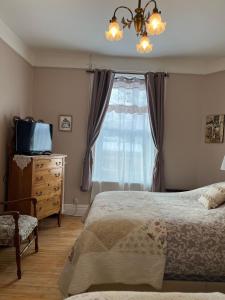 a bedroom with a bed and a television and a window at B&B Chez Hubert in Quebec City