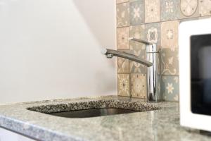 a kitchen counter with a sink and a faucet at Sunset Apartments in Ovar +31 photos