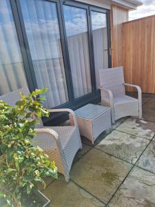 a balcony with wicker chairs and tables and windows at Room with a View in Glastonbury