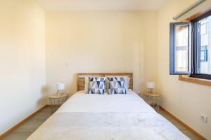 a bedroom with a large bed with two tables at Sunset Apartments in Ovar
