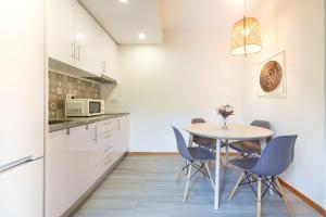 a kitchen with a table and chairs in a room at Sunset Apartments in Ovar