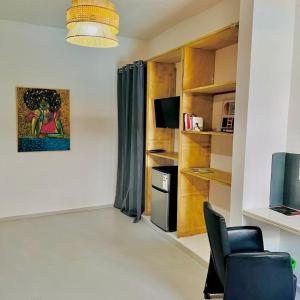 a living room with a chair and a television at La Brise de Ngaparou in Ngaparou