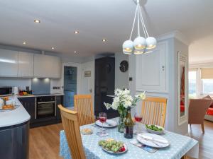 a kitchen and dining room with a table with food and wine at Bosula in Fowey +22 photos