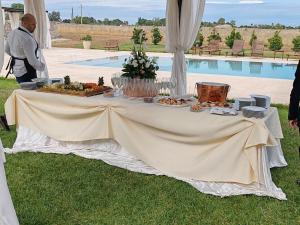 a table with food on it next to a pool at Agriturismo Masseria Quaremme in Carpignano Salentino