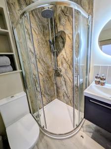 a bathroom with a shower with a toilet and a sink at Pudsey Loft Apartment in Pudsey