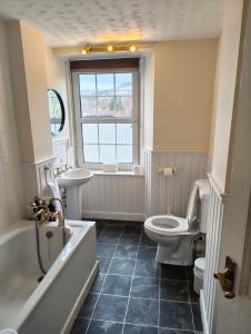 a bathroom with a tub and a toilet and a sink at Fintry Inn in Fintry
