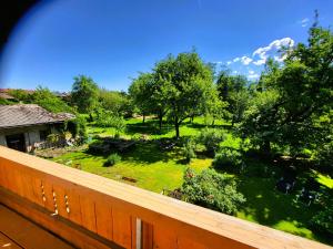 a balcony with a view of a yard with trees at Ferienwohnungen Hörterer | Chiemgau Karte in Grassau