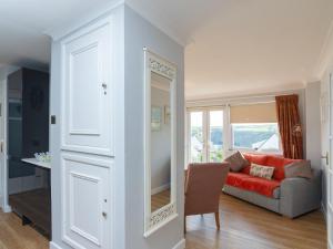 a living room with a red couch and a window at Bosula in Fowey
