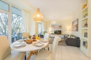 ein Esszimmer und ein Wohnzimmer mit Tisch und Stühlen in der Unterkunft Südwind 13 in Zempin