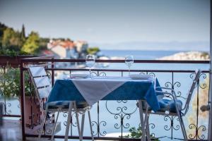 einen Tisch mit zwei Weingläsern auf dem Balkon in der Unterkunft Apartments Ana in Lastovo