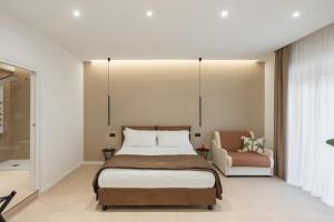 a bedroom with a bed and a chair at Cali Luxury Suites in Caserta