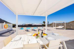 a white dining table and chairs on a patio at Villa Yaiza Secret 3 in Yaiza