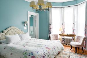 a bedroom with blue walls and a bed and a desk at The Jellybean Heritage Inn in St. John's