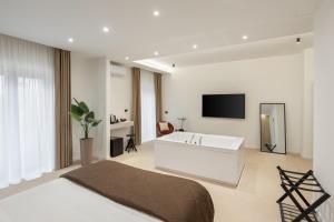 a bedroom with a bath tub and a television in it at Cali Luxury Suites in Caserta