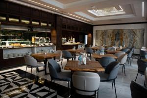 ein Restaurant mit Tischen und Stühlen und einer Bar in der Unterkunft Aivazovsky Congress Hotel & Spa in Gjumri