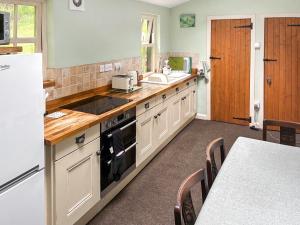 a kitchen with white cabinets and a counter top at Professors Cottage in Girvan