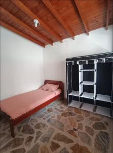 a small room with a bed and a shelf at Hostel La Casona in Medellín