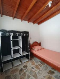 a room with a red bed and shelves at Hostel La Casona in Medellín