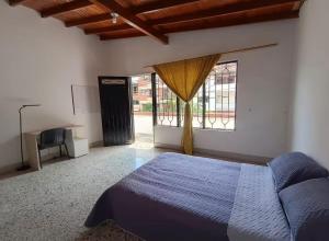a bedroom with a bed and a large window at Hostel La Casona in Medellín +14 photos