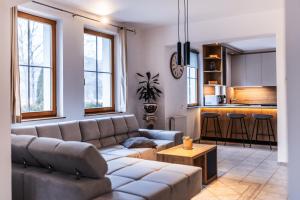 a living room with a couch and a kitchen at Vila Grad Bled - Sauna & Hot tub in Bled