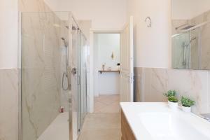 a bathroom with a glass shower and a sink at Primopiano - Olgettina in Vimodrone +42 photos