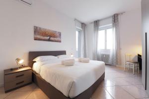 a bedroom with a large white bed and a desk at Primopiano - Olgettina in Vimodrone
