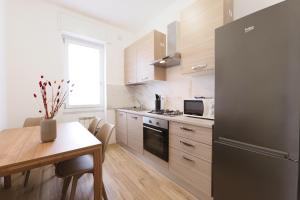 a kitchen with a black refrigerator and a table at Primopiano - Olgettina in Vimodrone