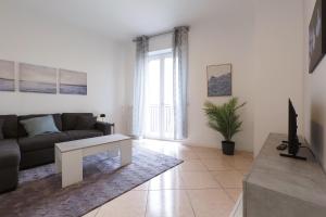 a living room with a couch and a table at Primopiano - Olgettina in Vimodrone
