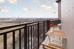 a balcony with a wooden bench and a vase of flowers at Primopiano - Olgettina in Vimodrone