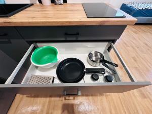 a kitchen stove with pots and pans in a drawer at Apartamenty przy Galerii in Kluczbork