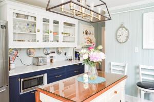 a kitchen with blue cabinets and a vase of flowers on a counter at The Jellybean Heritage Inn in St. John's