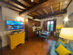 a living room with a blue couch and a tv at La Loggia di Montefienali in Gaiole in Chianti