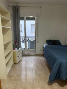 a bedroom with a bed and a view of a balcony at Habitación individual in Madrid