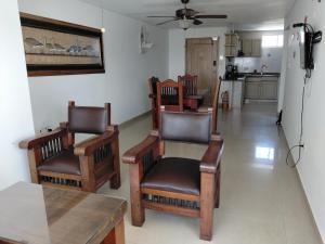 a living room with chairs and a table and a refrigerator at Rodadero brisas marinas in Gaira