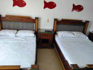 two beds sitting next to each other in a bedroom at Rodadero brisas marinas in Gaira +21 photos